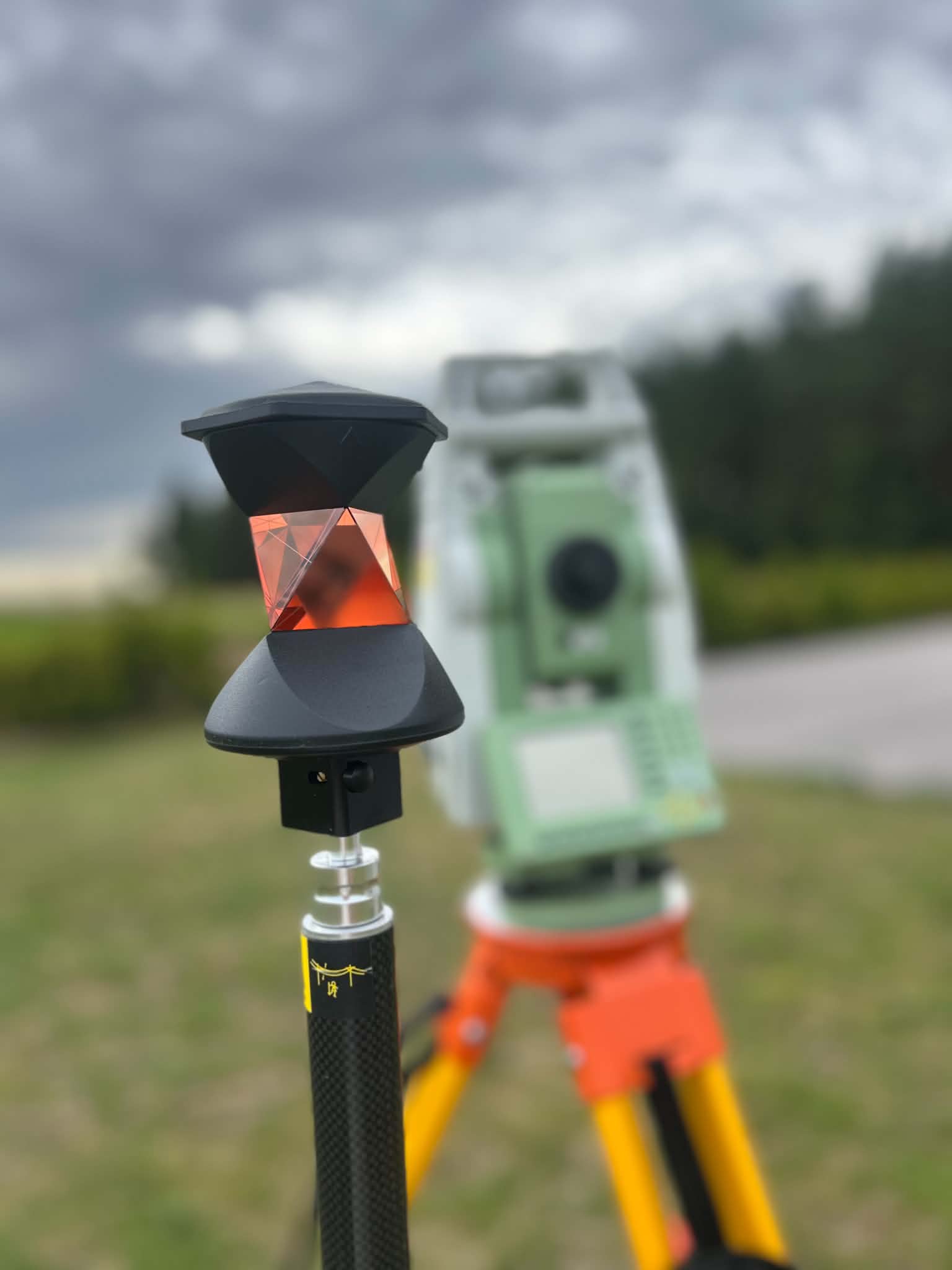 Mätprisma och totalstation på ett uppdrag ute i fält